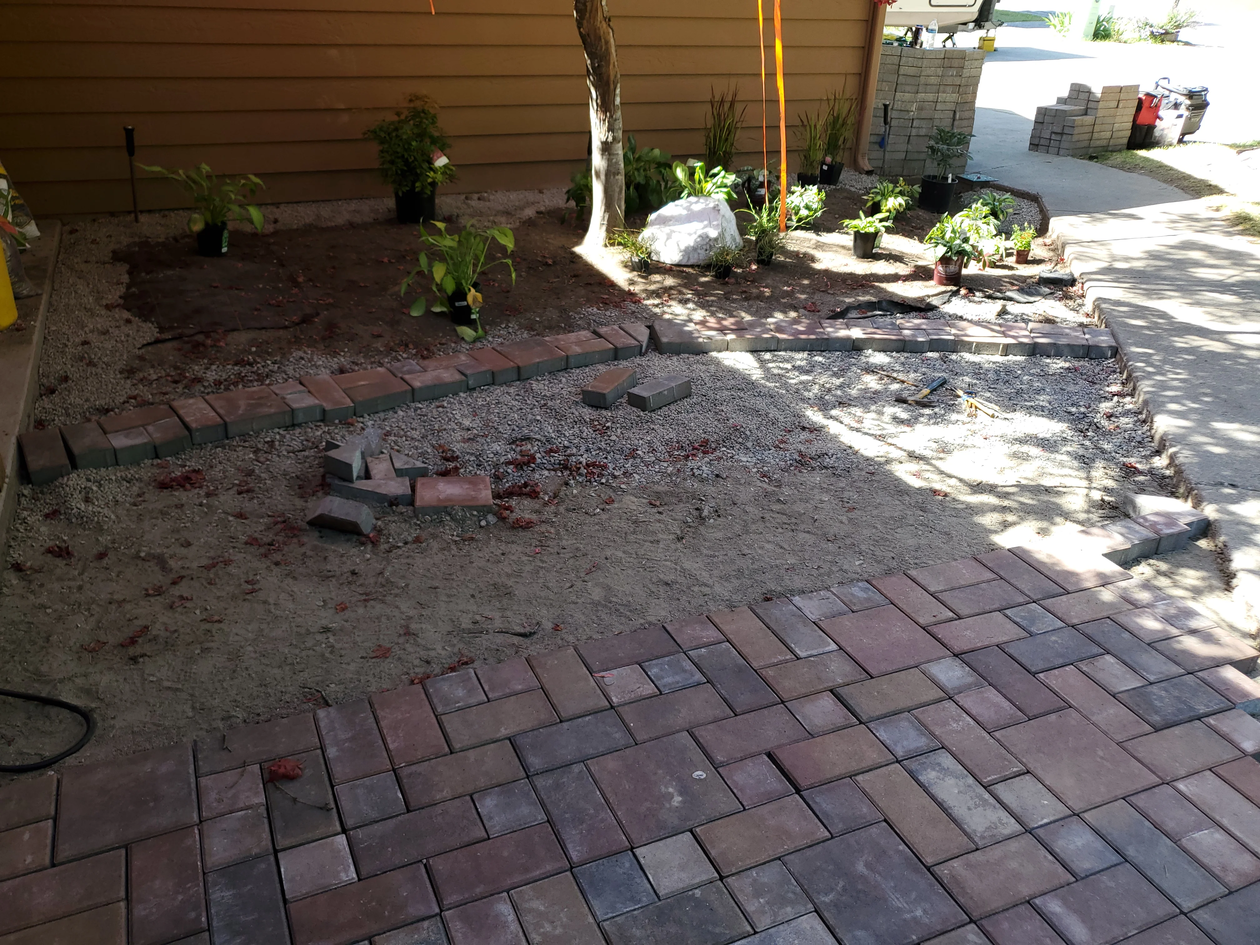 Clay brick pavers in herringbone pattern during backyard hardscape installation