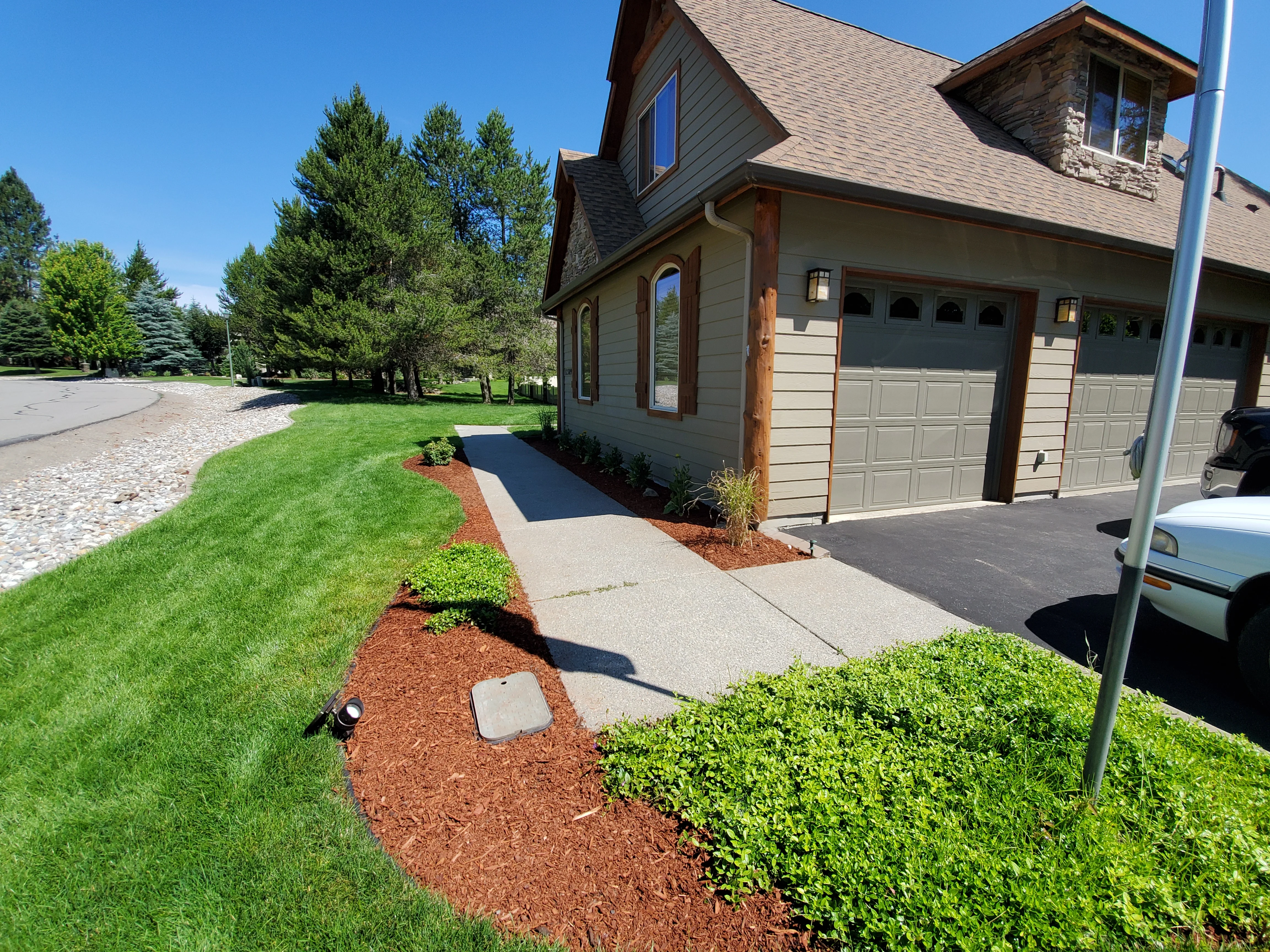 Freshly installed cool-season grass lawn on a residential property in Coeur d'Alene, Idaho, with clean edges and uniform turf coverage across a graded front yard. Bee Stung Yard Care LLC completed the full installation including soil preparation and finish grading.